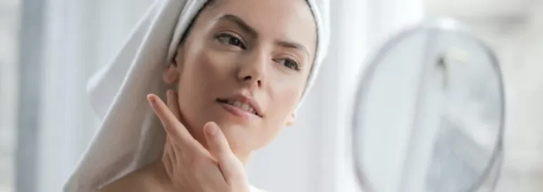 Women looking at her face in mirror