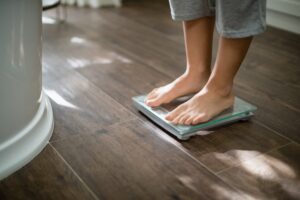 A woman standing on the scales, measuring her weight