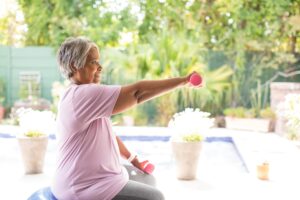 Image of an older lady working out with dumbbells.
